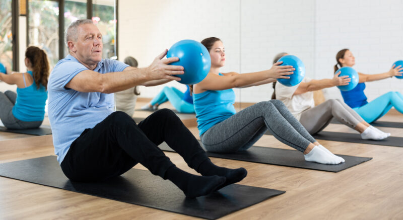 Pilates-Starter-Workshop PIlates Training mit dem Ball auf der Matte, durchgeführt von jungen Menschen und vom Opa; gute Ergänzung zur ganzheitlichen Heilmassage - PIlates für alle!